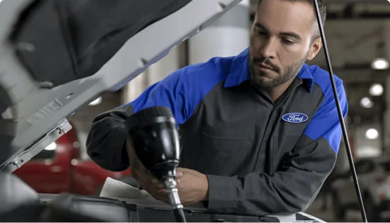 The modern service bay at Fremont Ford Lander with a technician working on a truck.